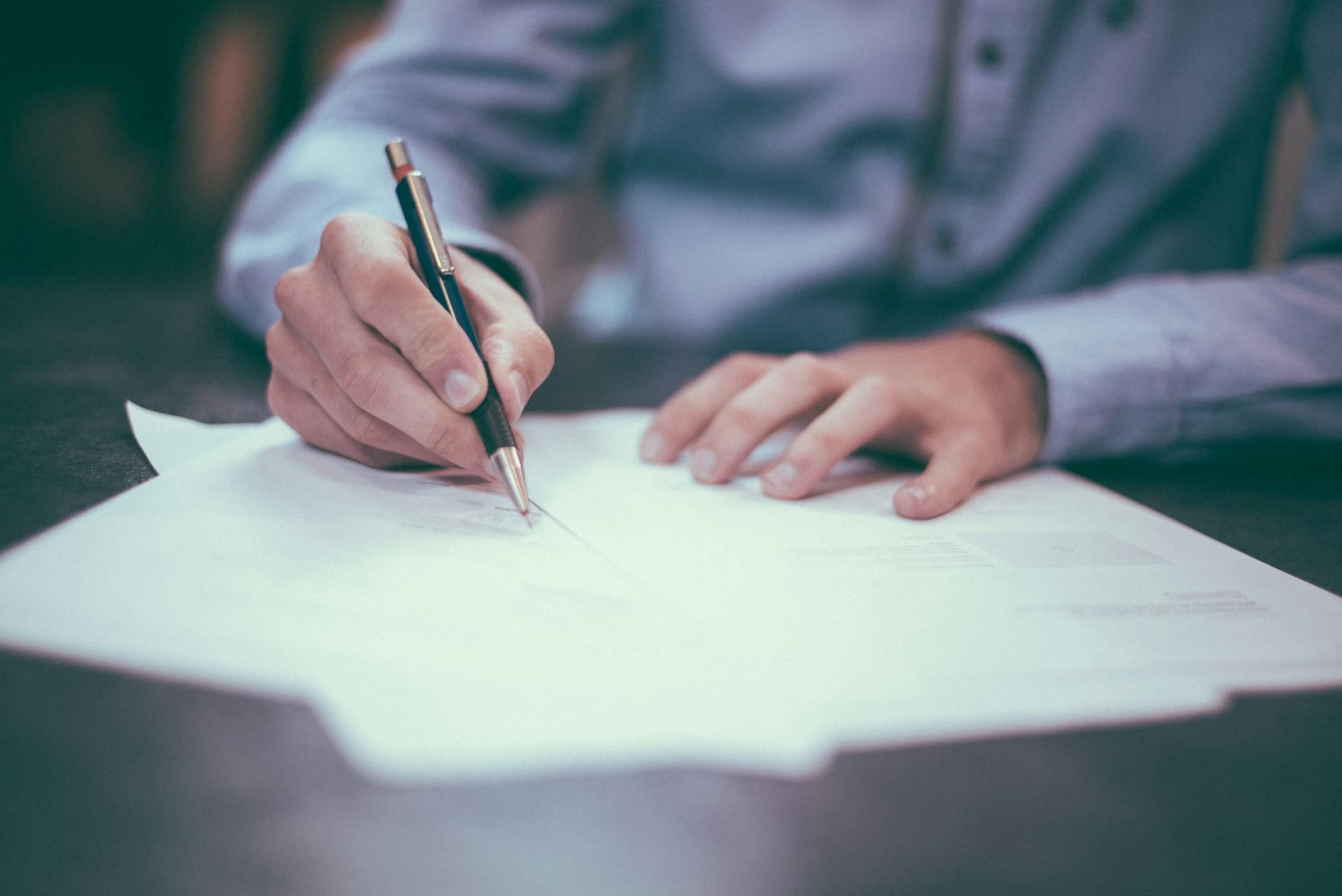 A business owner reading through a written proposal with a pen in hand