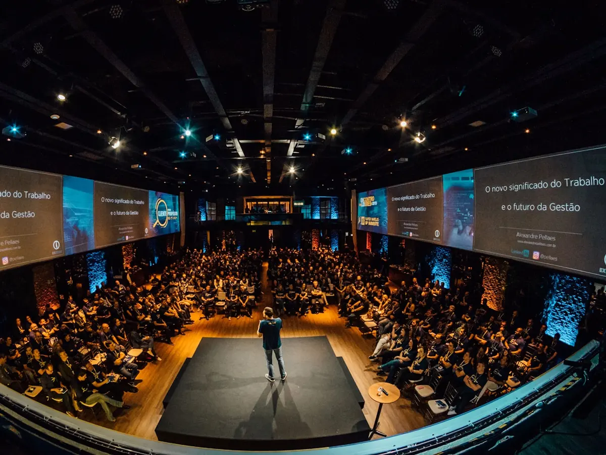 Speaker on stage in front of a large conference audience
