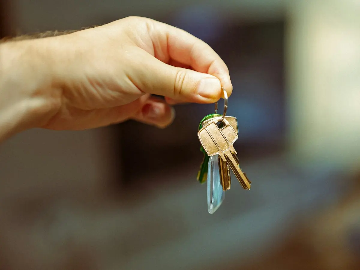 Hand holding a set of keys to a rental property