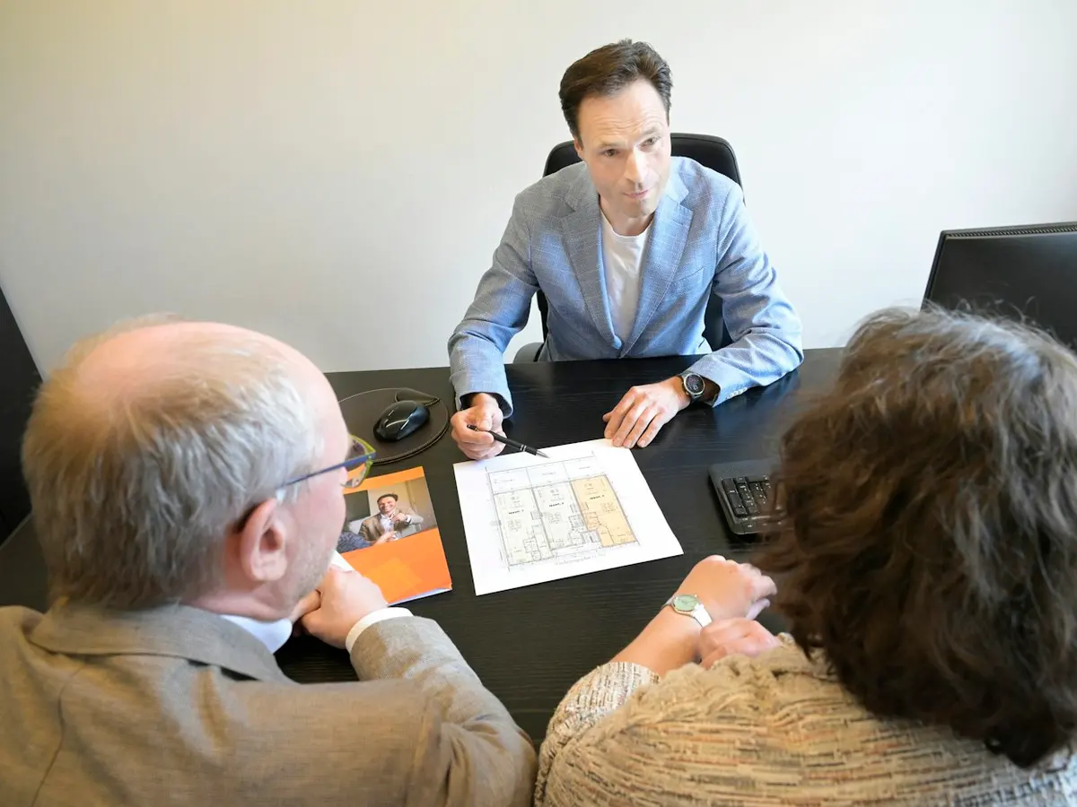 Property adviser going over plans with two owners at a desk
