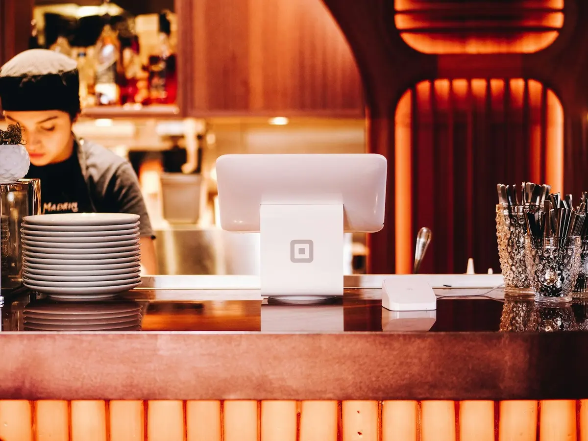 Server at a point-of-sale terminal behind the counter