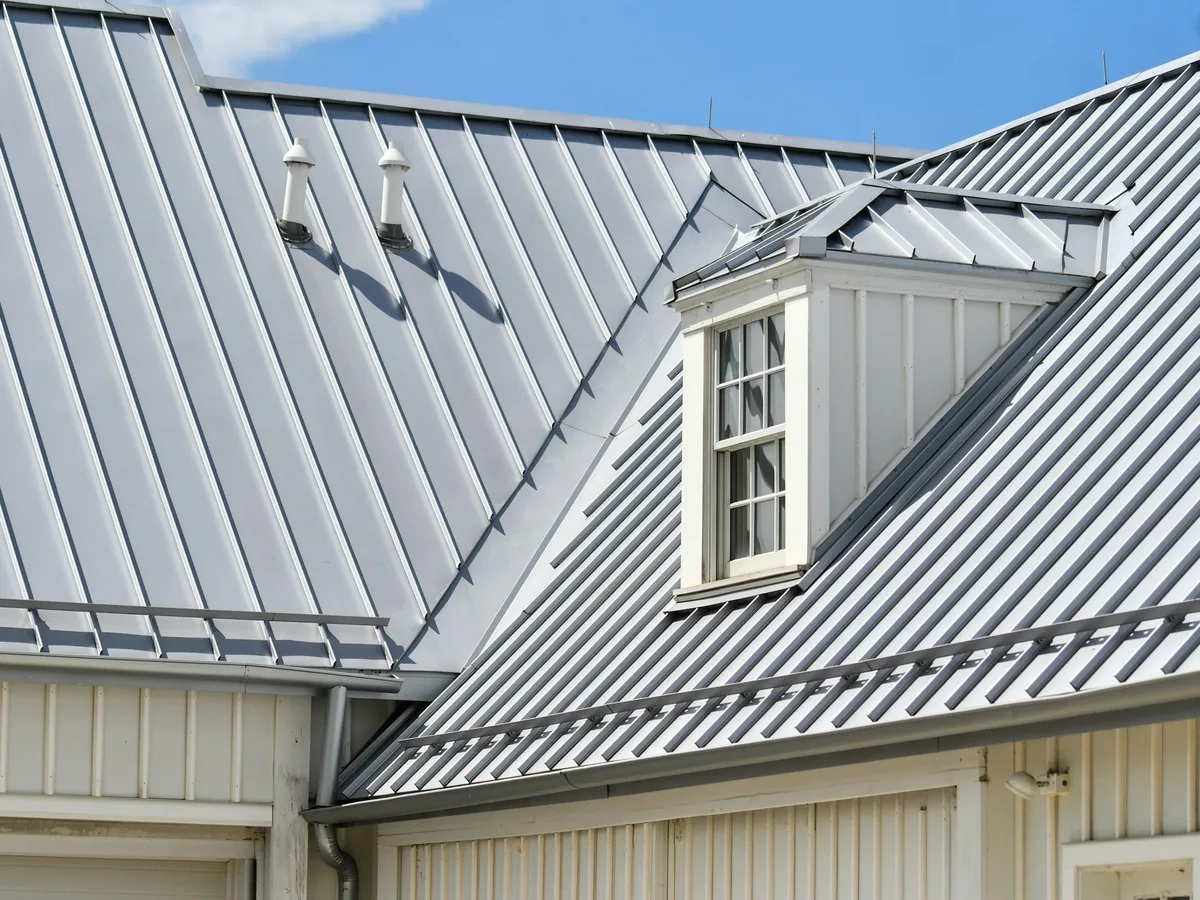 Finished standing-seam metal roof with a white dormer window