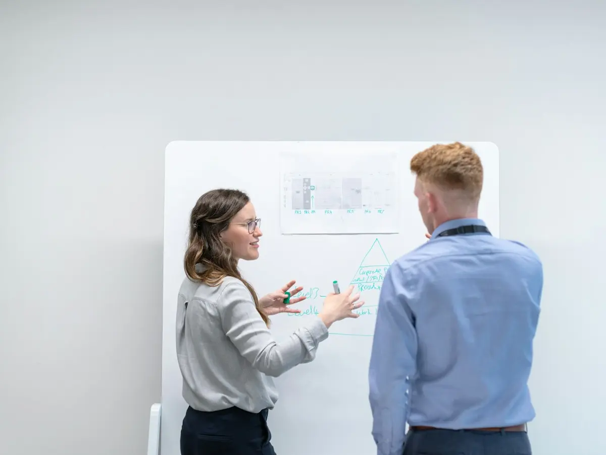 Two colleagues planning at a whiteboard
