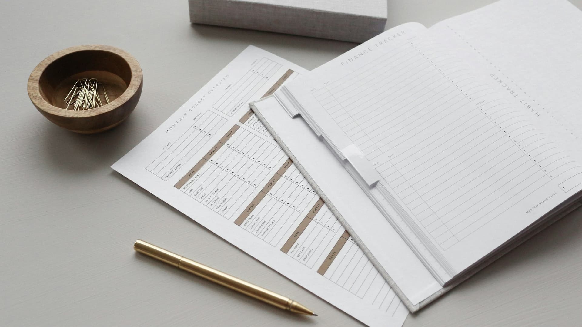 Monthly finance reports laid out for review beside a pen