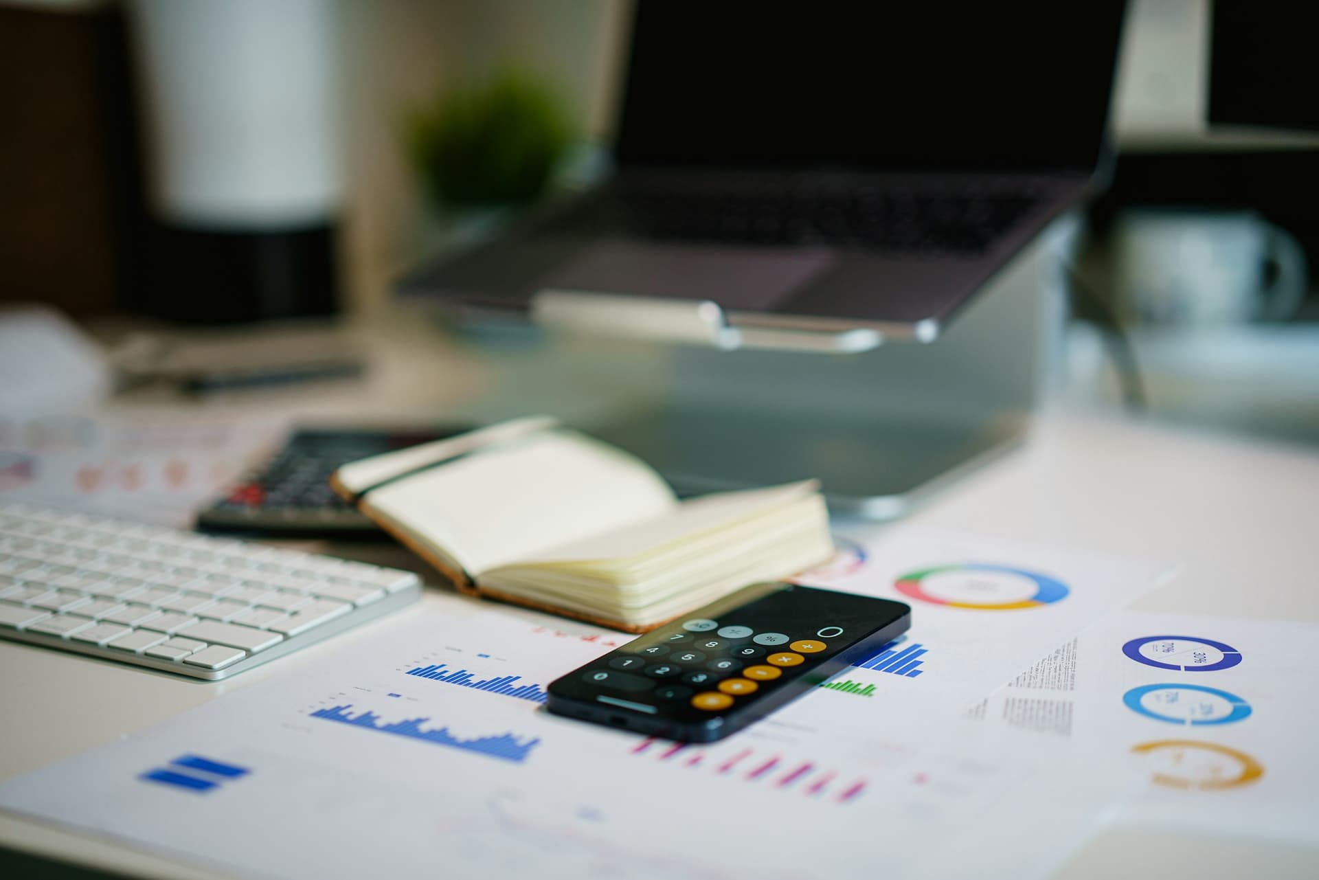 Financial charts, a calculator and a notebook on a bookkeeping desk