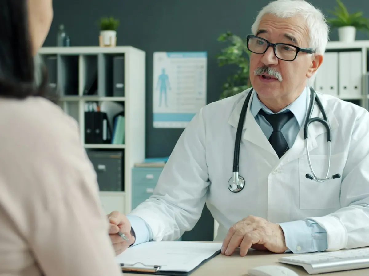 Doctor talking with a patient across his desk