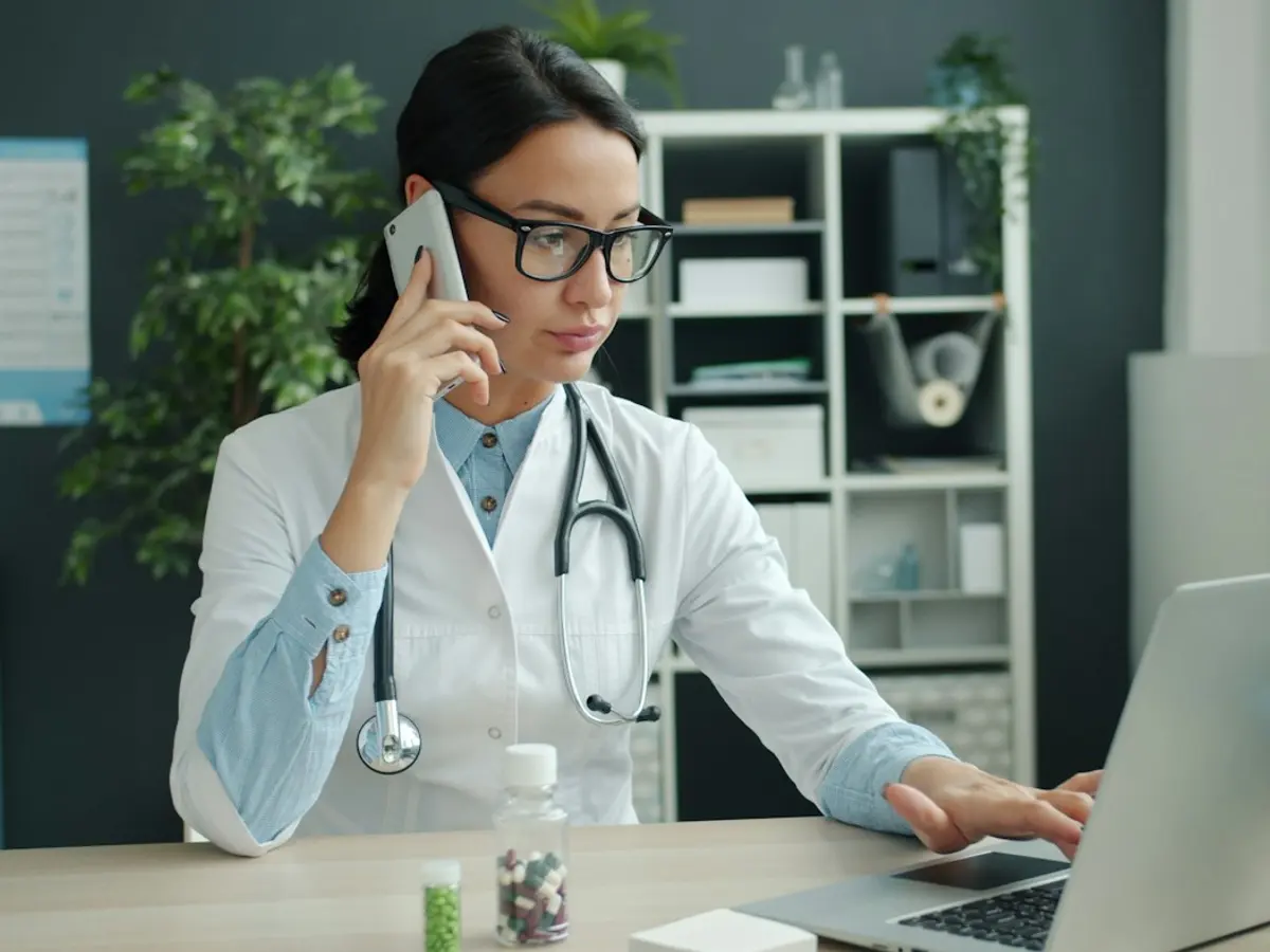 Physician on the phone while working at her laptop