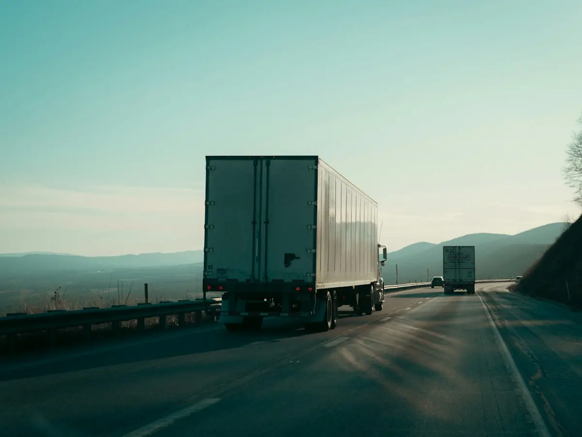 Semi-truck on an open highway at sunrise