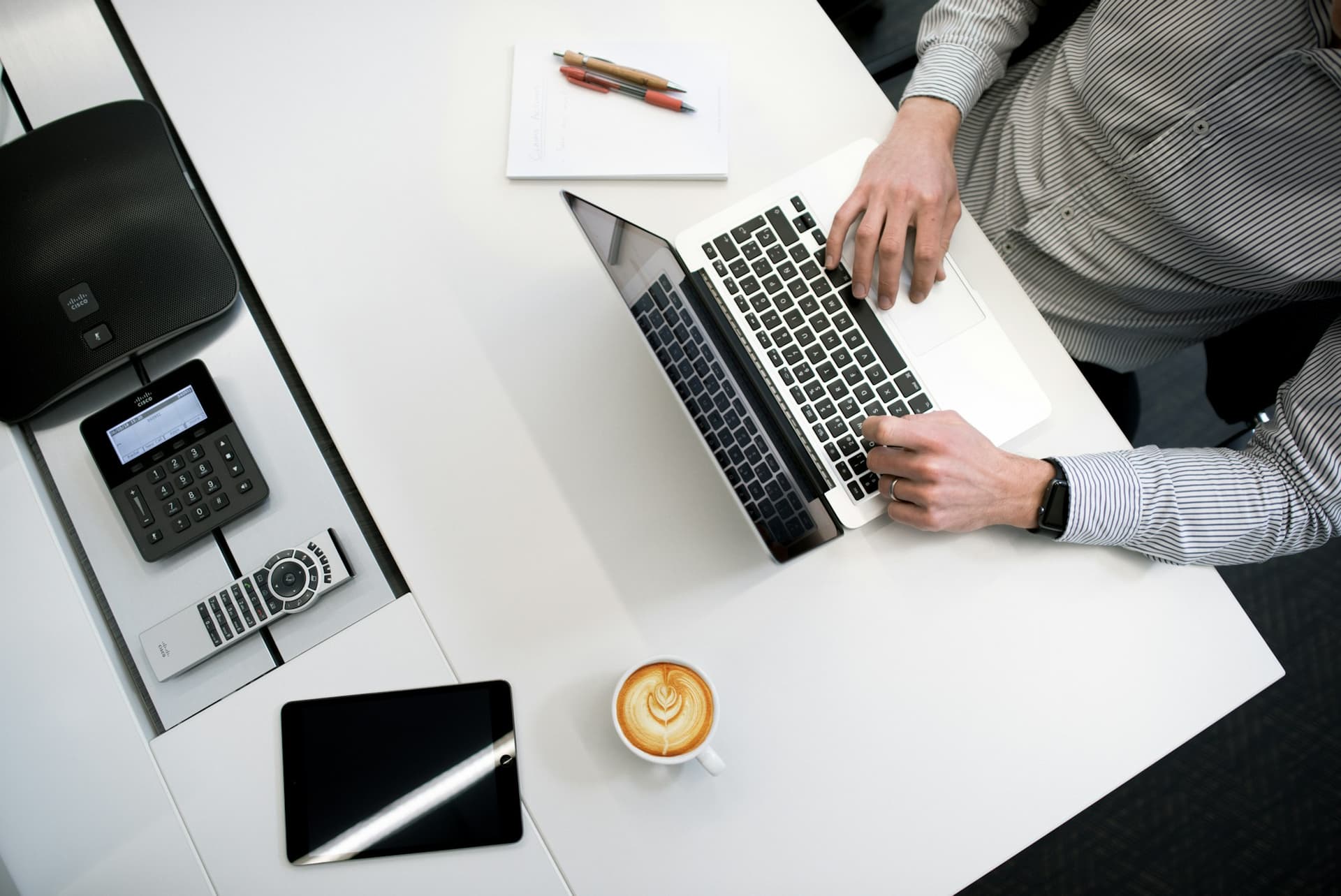 Overhead view of a laptop and card reader on a clean desk during a bookkeeping session