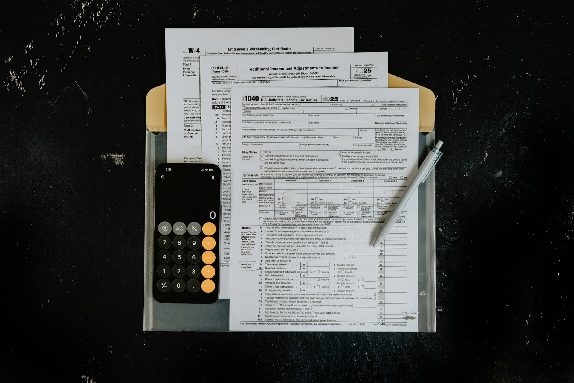 Completed tax forms in a document folder beside a calculator and pen